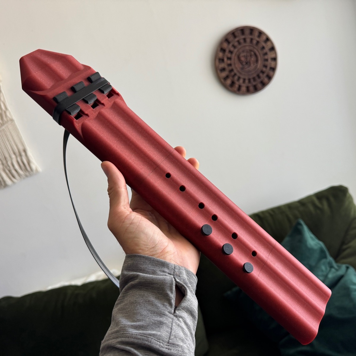 Crimson triple drone flute held in hand