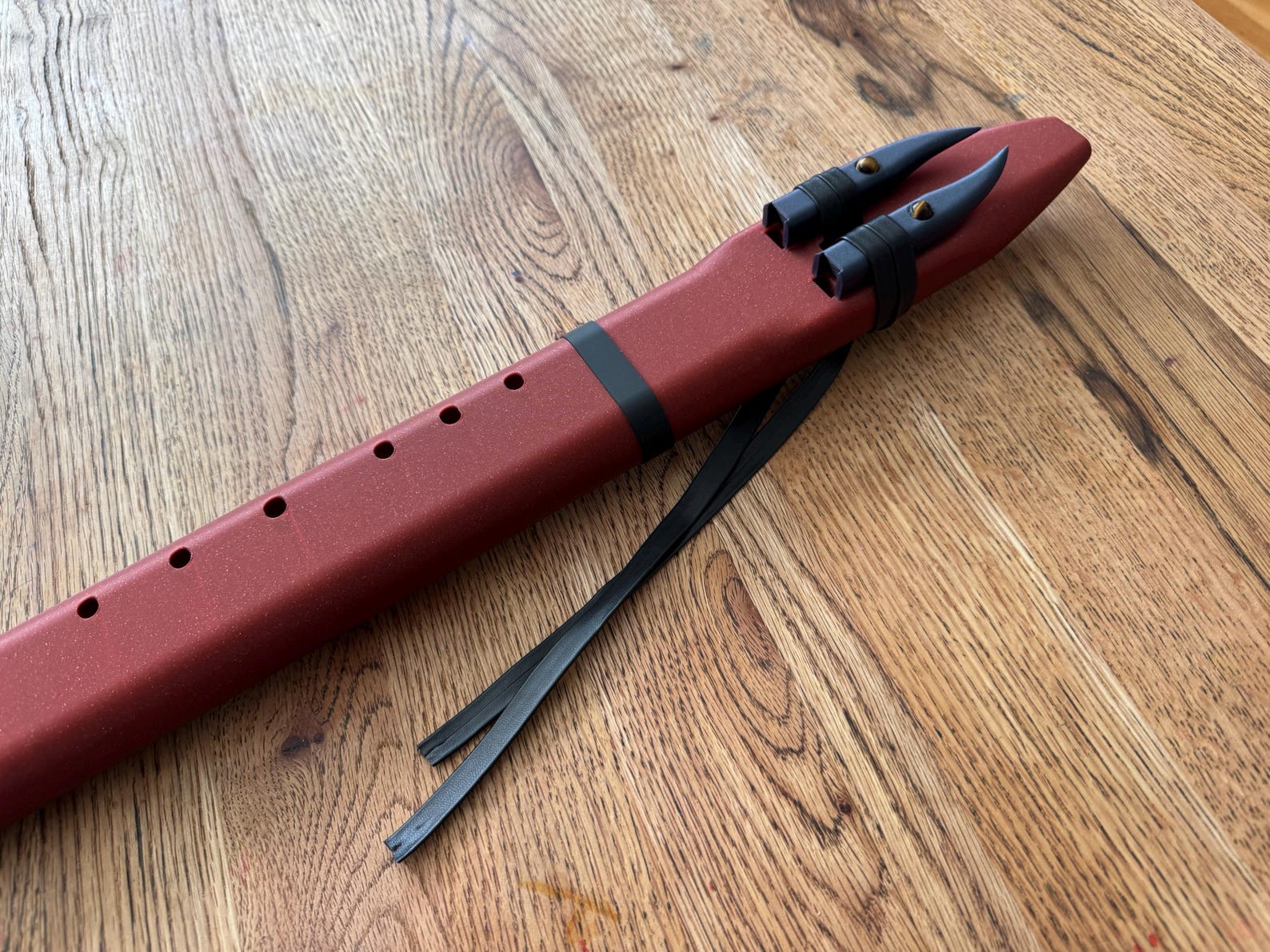 Full side view of the Crimson Drone Flute on oak floor