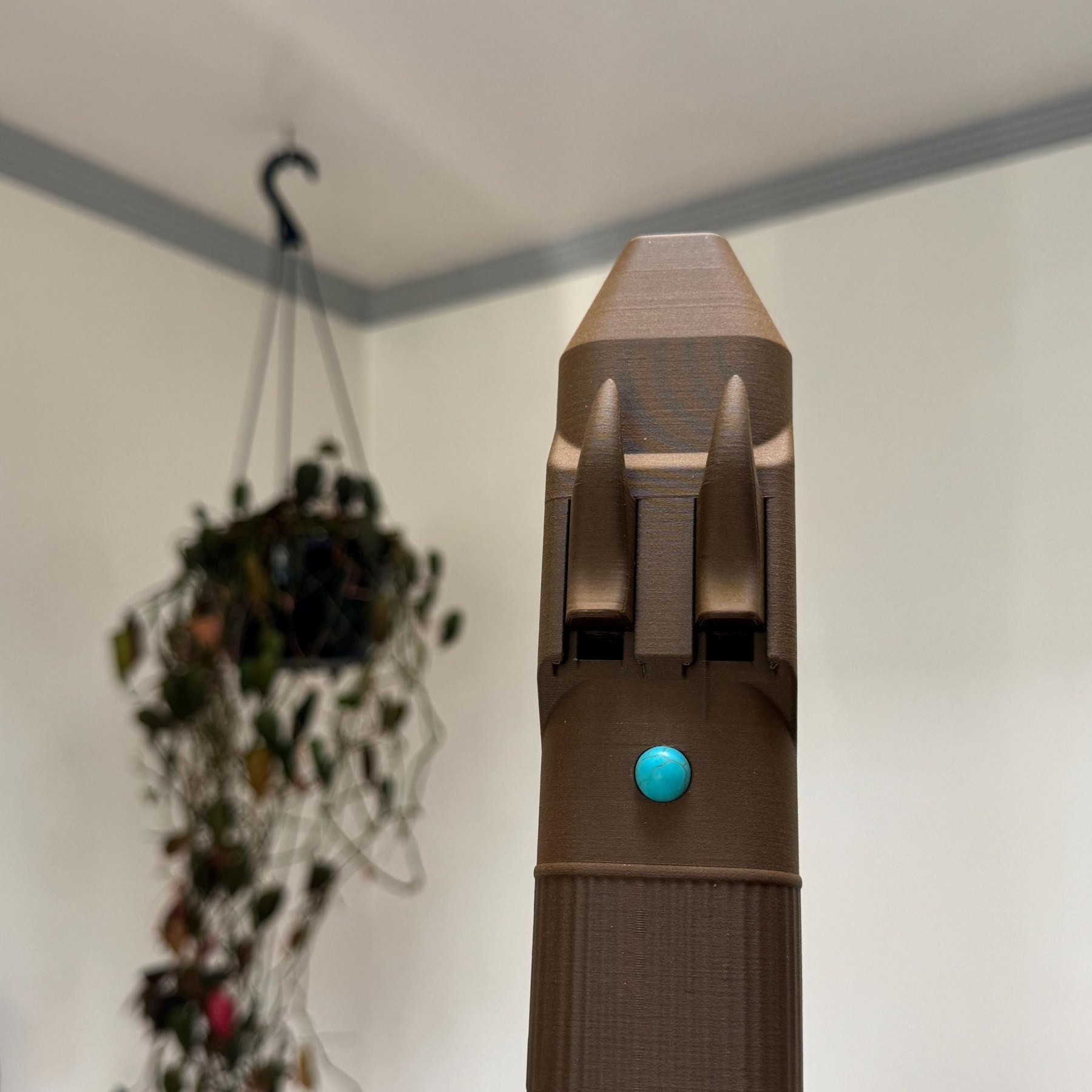 Upright close view of the two horn-shaped blocks and turquoise accent on the drone flute mouthpiece