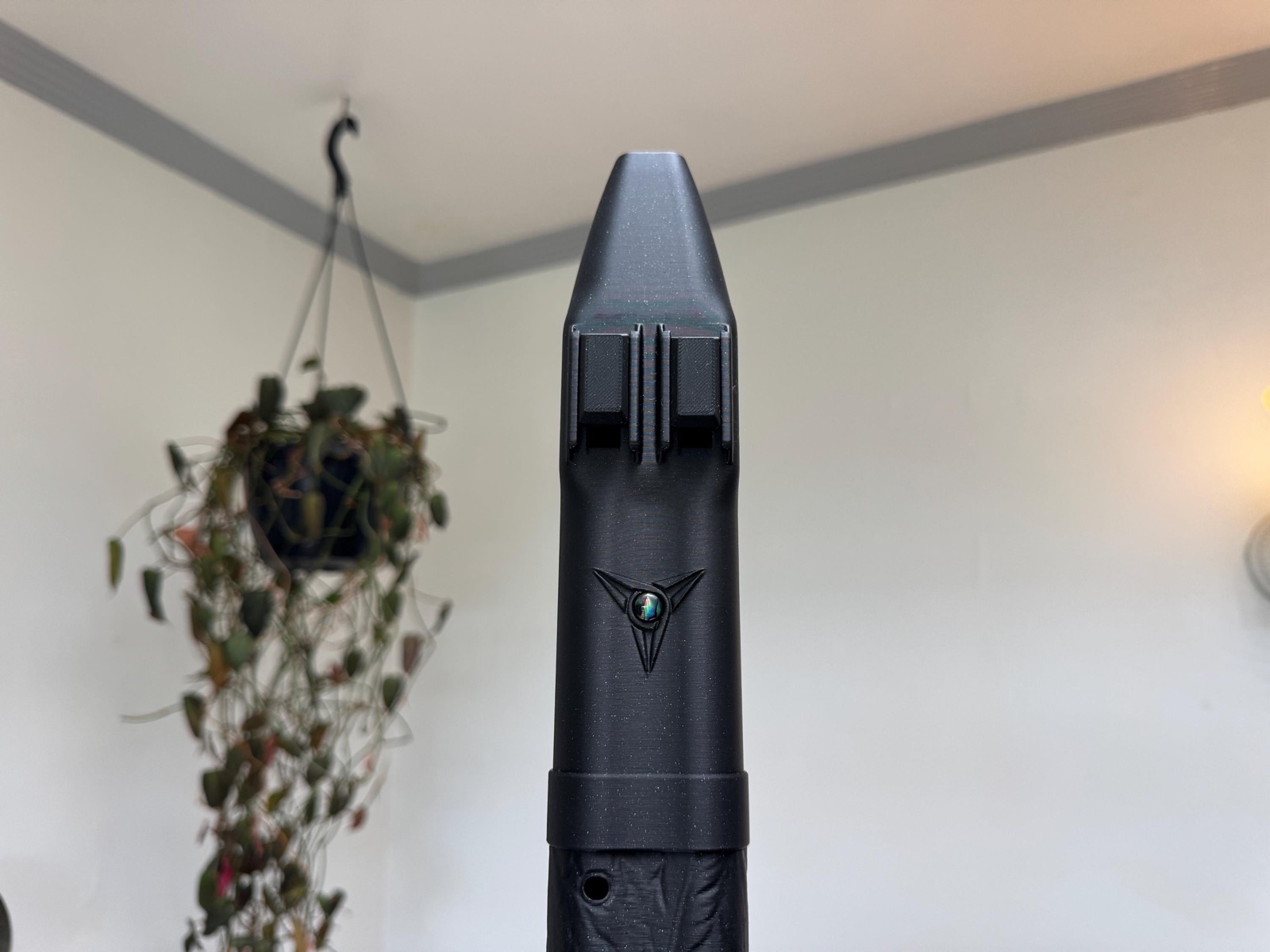 Black Raven triple drone flute seen head-on, showing the three drone blocks and the mother-of-pearl inlay in a three-pointed detail