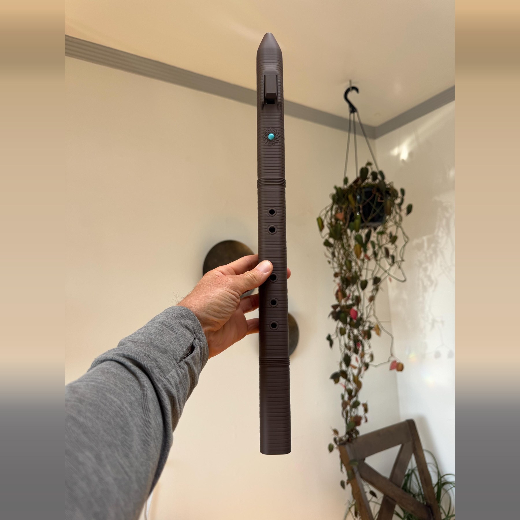 Full length view of the F sharp 4 triangle flute held upright in one hand